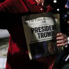 Un manifestante proTrump muestra un ejemplar de un periódico con el titular: 'Trump, presidente'.