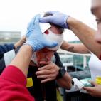 Un sanitario atiende a un manifestante herido después de las cargas de los Mossos d'Esquadra contra los miles de personas que se agolpan ante el Aeropuerto de El Prat después de que la plataforma Tsunami Democràtic haya llamado a paralizar la...