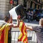Dos a&ntilde;os despu&eacute;s del refer&eacute;ndum ilegal del 1 de octubre de 2017, dos hombres muestran una de las urnas de aquel d&iacute;a a los polic&iacute;as nacionales apostados ante la comisar&iacute;a de la c&eacute;ntrica Via La...