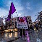 Una mujer sostiene una bandera feminista y una pancarta en la plaza de Zocodover, este lunes en Toledo, para conmemorar el Día Internacional de la Mujer.