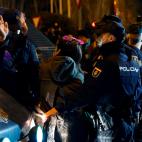Efectivos policiales vigilan a asistentes a una sentada improvisada en la plaza de Neptuno de Madrid con motivo de la celebración del Día Internacional de la Mujer.