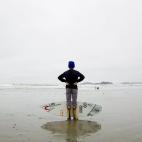El surfista Reed Platenious sujeta una tabla durante el campeonato de surf canadiense en Tofino, Canadá.