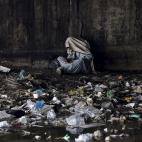 Un drogodependiente afgano se cubre la cabeza con una bufanda bajo un puente en Kabul, Afganistán.