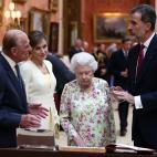 Los reyes de Espa&ntilde;a observan una vitrina con objetos espa&ntilde;oles en el palacio de Buckingham, a donde han llegado junto a Isabel II y el duque de Edimburgo.