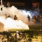 La policía de Ferguson despeja las calles mediante el lanzamiento de bombas de humo.