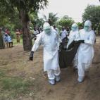 Monjas liberianas cargan el cuerpo de una víctima de la enfermedad en su casa en la comunidad de Banjor, a las afueras de Monrovia.