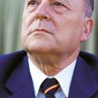 Primer plano de Blas Piñar. La bandera de España forma parte habitual de su indumentaria.