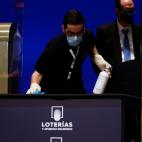 Un operario desinfecta el mobiliario del sorteo.