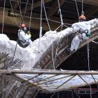 Varios de los trabajadores, sobre uno de los arcos de la catedral parisina