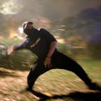 Un manifestante violento lanza una piedra.