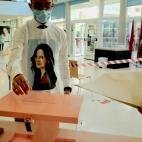 Un joven vota con una camiseta con la cara de Isabel Díaz Ayuso.