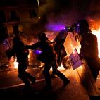 Polic&iacute;as corren ante el fuego.