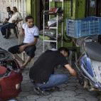 Un hombre repara una moto