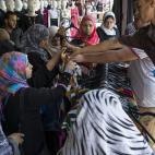 Mujeres compran ropa en un puesto