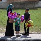 Una mujer compra un globo a un vendedor