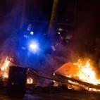 Un radical se dispone a lanzar una bengala a los antidisturbios.