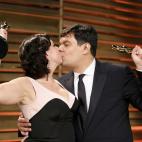 El matrimonio de Kristen Anderson-Lopez y Robert Lopez se besa y alza las estatuillas que han ganado por la cancion de Frozen Let it Go (Mejor Canción Original).