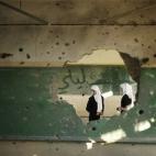 Dos estudiantes palestinas observan los daños que los ataques israelíes han provocado en su escuela en Gaza.