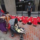 Activistas vestidas de rojo protestan delante del Ministerio de la Mujer de Lima en lo que representa una "alfombra roja" humana como símbolo de que los derechos de las mujeres están siendo pisoteados por el Gobierno.