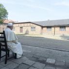 El papa Francisco sentado frente a un barracón durante su visita al campo de concentración nazi de Auschwitz.