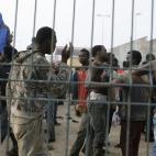 Los inmigrantes se felicitan y conversan tras el éxito del salto.