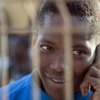 Un inmigrante habla por el móvil en el CETI tras haber logrado con éxito el mayor asalto a la valla de Melilla que se ha registrado hasta la fecha.