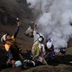 Un grupo de indonesios recogen monedas que les lanza la tribu Tengger durante el Yadnya Kasada, en el Monte Bromo, Indonesia.