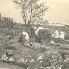 Familias de raza negra buscando algo que rescatar entre los restos del incendio