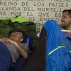 Varios sin techo con un grupo de extranjeras que les lleva comida y agua de vez en cuando.