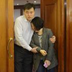 Parientes de los pasajeros del vuelo MH370 abandonan la sala de un hotel tras ser informados por Malaysia Airlines de que el avión se estrelló y no hay supervivientes.