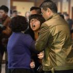 Familiares de los pasajeros de vuelo malayo lloran tras el discurso del primer ministro de Malasia, Najib Razak, en el que da a conocer que el avión se estrelló en el océano Índico.