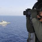 Fotografía de la Armada de la República de Singapur, que muestra a un miembro de la Fuerza Aérea a bordo de un helicóptero mientras participa en la búsqueda del avión.