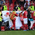 Medics stretcher Denmark's midfielder Christian Eriksen off the pitch after he collapsed during the UEFA EURO 2020 Group B football match between Denmark and Finland at the Parken Stadium in Copenhagen on June 12, 2021. (Photo by Jonathan NACKST...