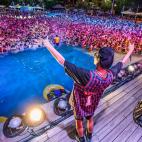 Un artista se dirige al p&uacute;blico congregado en la piscina.