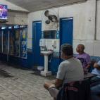 Varios hombres ven la ceremonia de inauguración de los Juegos desde un restaurante cercano al estadio."Los Juegos sólo han traído más injusticia social, la gente que ya era rica es ahora más rica", explica Luiza de Andrade, directora de doc...