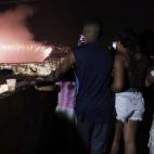 Una familia fotografía los fuegos artificiales.