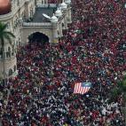 Un grupo de manifestantes sostiene una bandera de Malasia en la plaza de la Independencia de Kuala Lumpur.