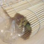 Con la ayuda de una esterilla de bambú para sushi, enrollamos las capas con mucho cuidado, apretando fuertemente.