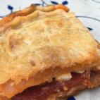 Basta con poner el tomate frito casero sobre la masa quebrada, el atún, el pimiento del piquillo a tiras, el huevo cocido a rodajas y espolvorear un poco de orégano, poner la otra placa de masa encima y sellarla... ¡y al horno! La receta comp...