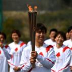 La futbolista japonesa Azusa Iwashimizu, portando la llama olímpica.