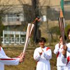 Azusa Iwashimizu entrega la llama al joven estudiante Asato Owada.
