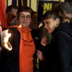 City councillor of Barcelona's city hall and member of radical left-wing Catalan independentist political party CUP (Popular Unity Candidates) Maria Robira (R) and CUP's deputy Mireia Vehi burn a picture of Spain's King during an anti-monarchy d...