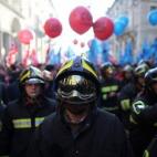 Bomberos marchan en Turín durante una huelga general en protesta contra el Gobierno de Matteo Renzi por su reforma laboral.
