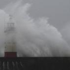 Las olas rompen sobre el puerto y el faro de Newhaven, al sur de Inglaterra.