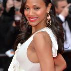 Saldana con melena ondulada y brillante, eyeliner con rabillo suave y labios rojos.