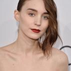 Mara recuerda a un retrato clásico con su pelo barrido y un potente color de labios.