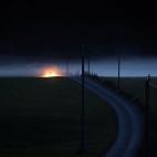 Entre los bancos de niebla se observan los faros de un coche cerca de Guenzach (Alemania).