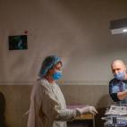 Aleina mira desde su camilla a su beb&eacute; reci&eacute;n nacida, atendida por los sanitarios.