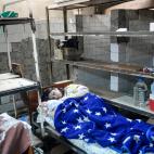 Una mujer reci&eacute;n parida contempla a su beb&eacute; en el s&oacute;tano del hospital.