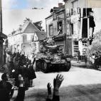 Sainte Mere Eglise, Francia. Una columna blindada francesa pasando por el pequeño pueblo francés de Saint Mere Eglise recibiendo una cálida bienvenida de los vecinos